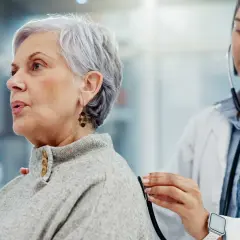 Médecin écoutant le souffle au cœur d'une patiente âgée avec un stéthoscope.