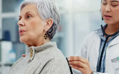 Médecin écoutant le souffle au cœur d'une patiente âgée avec un stéthoscope.