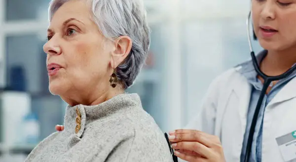 Médecin écoutant le souffle au cœur d'une patiente âgée avec un stéthoscope.