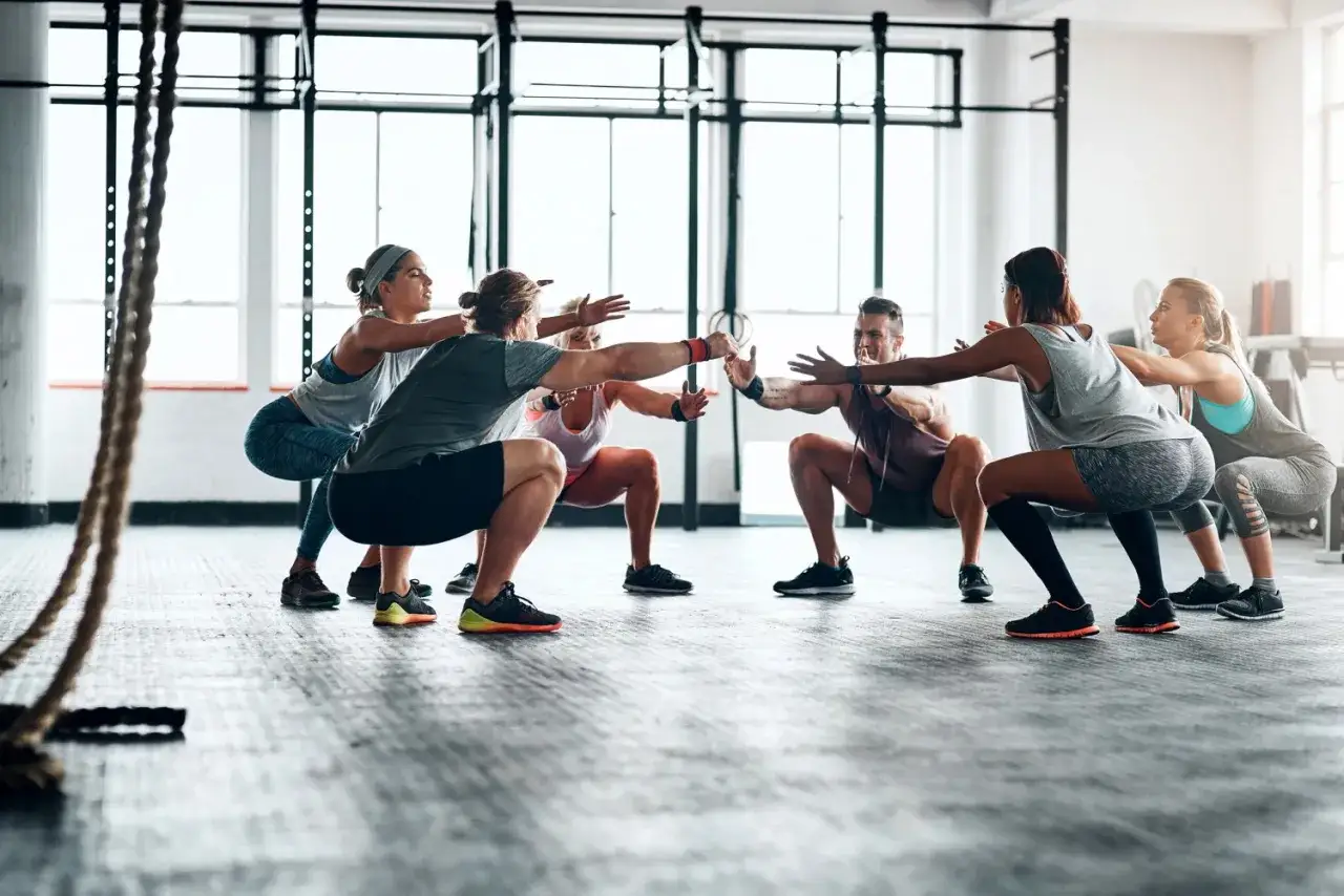 Groupe de personnes faisant des squats dans une salle de sport. Un excellent sport pour maigrir et se muscler.