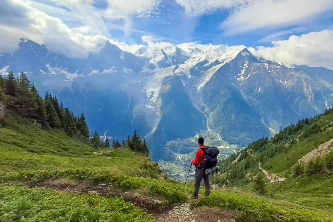 Randonneur contemplant les majestueuses montagnes enneigées. Combien de jours de marche pour atteindre ces sommets ?