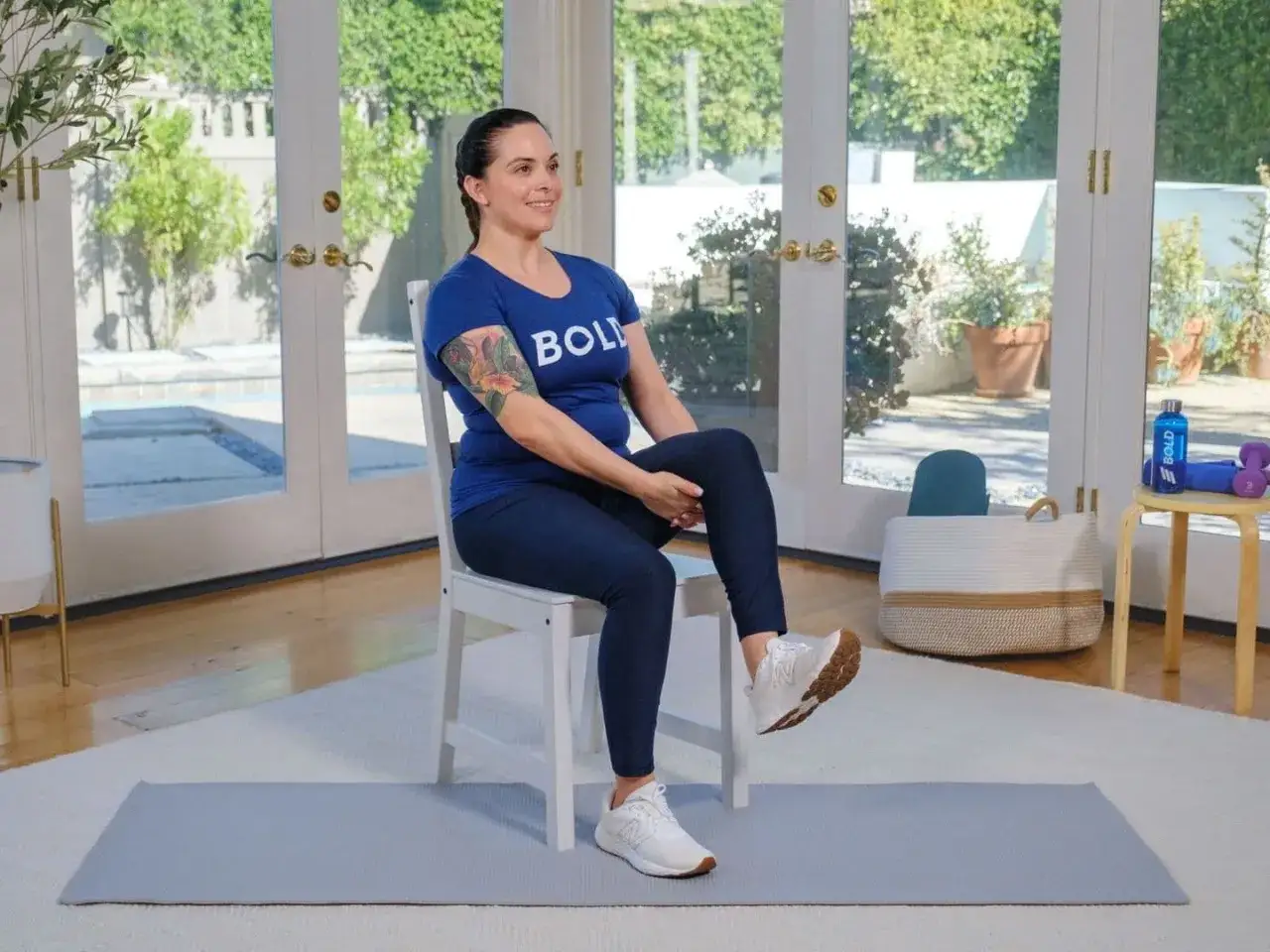 Fiche technique gym douce pour personne âgée : une femme assise sur une chaise, jambe levée, pour un exercice simple et efficace.