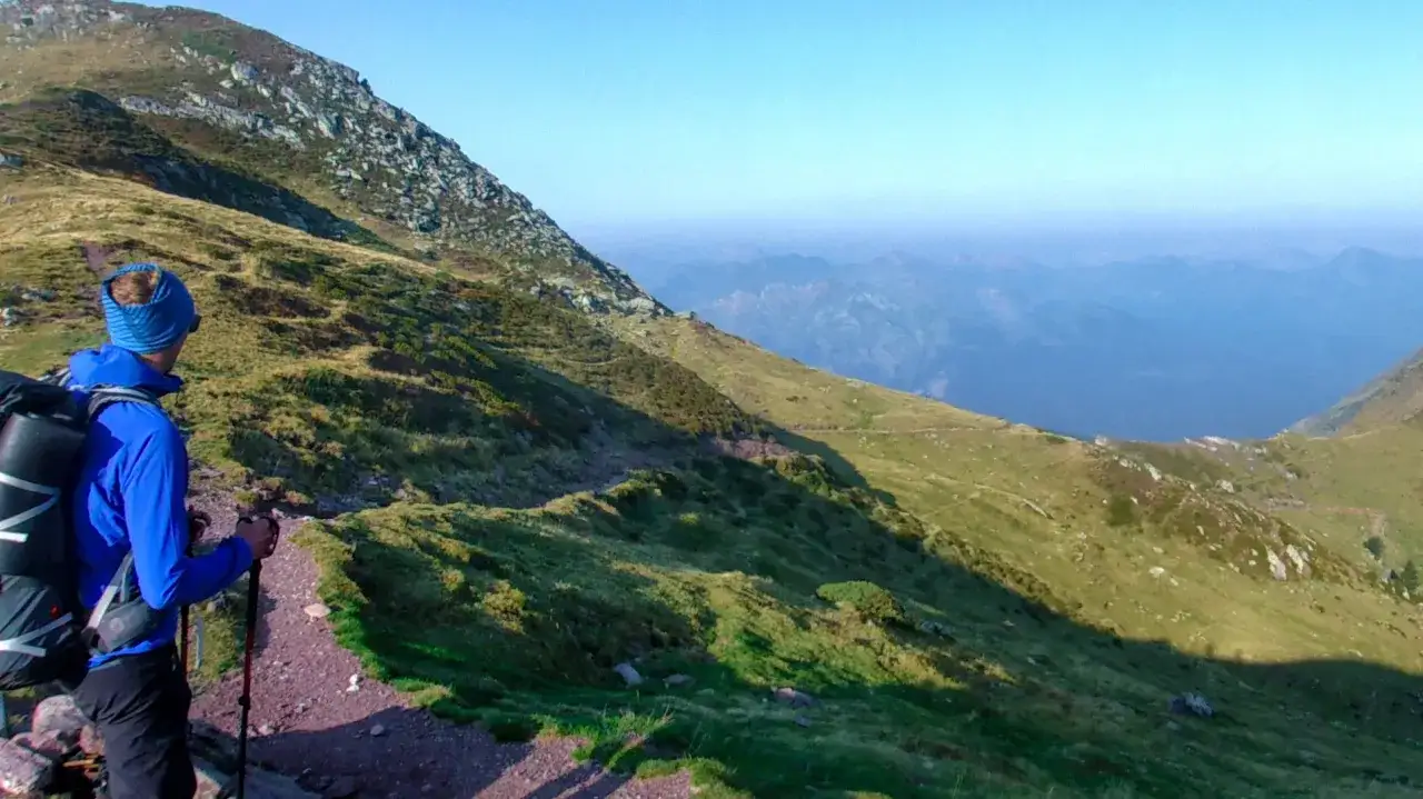 Randonneur contemplant un paysage montagneux, une parfaite destination randonnée.